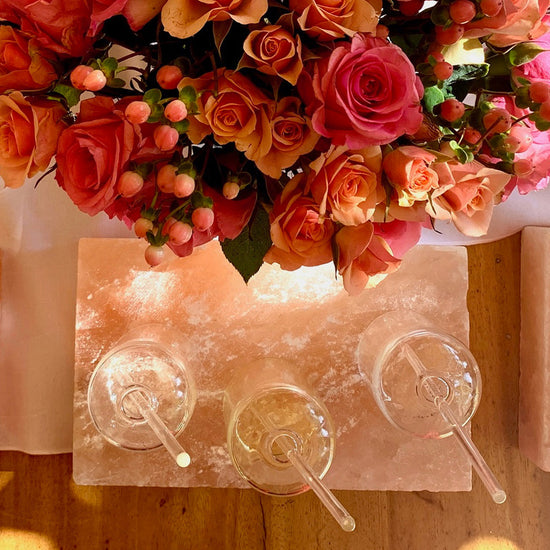 photo looking down at table with flower bouquet and clear bottles of fragrance oils